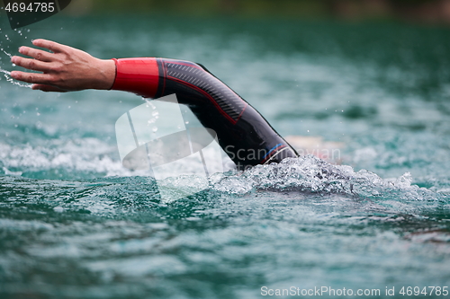 Image of triathlon athlete swimming on lake wearing wetsuit