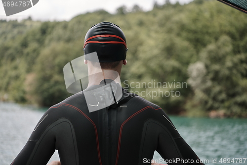 Image of triathlon athlete getting ready for swimming training on lake