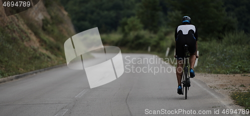 Image of triathlon athlete riding a bike wearing black