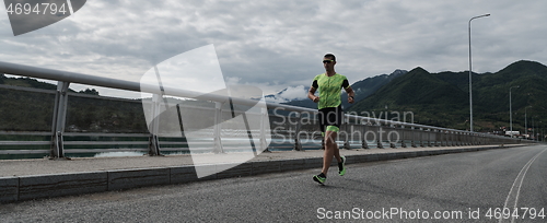 Image of triathlon athlete running on street