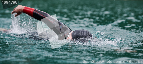 Image of triathlon athlete swimming on lake wearing wetsuit