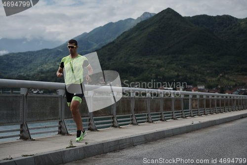 Image of triathlon athlete running on street