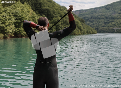 Image of triathlon athlete getting ready for swimming training on lake