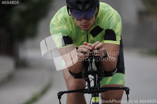 Image of triathlon athlete riding a bike on morning training