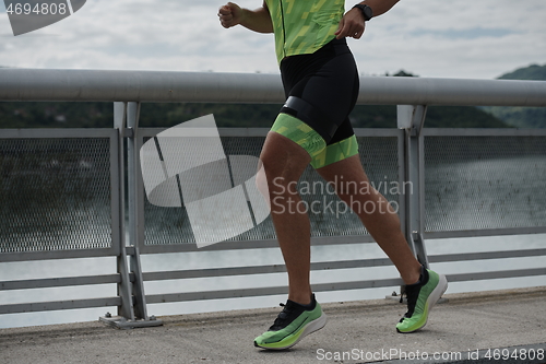 Image of triathlon athlete running on street