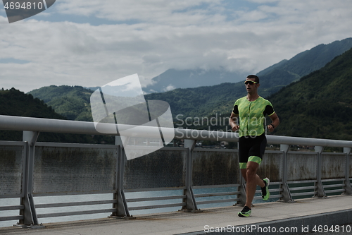 Image of triathlon athlete running on street