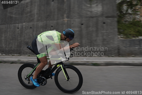 Image of triathlon athlete riding a bike on morning training