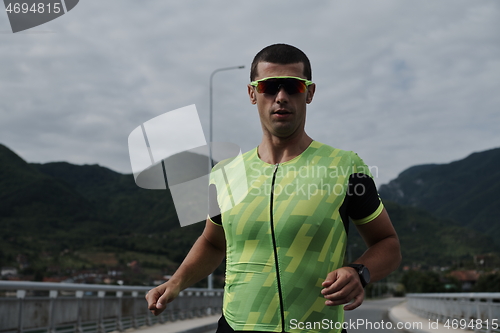 Image of triathlon athlete running on street