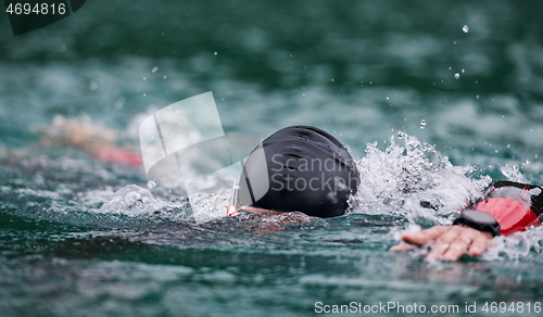 Image of triathlon athlete swimming on lake wearing wetsuit