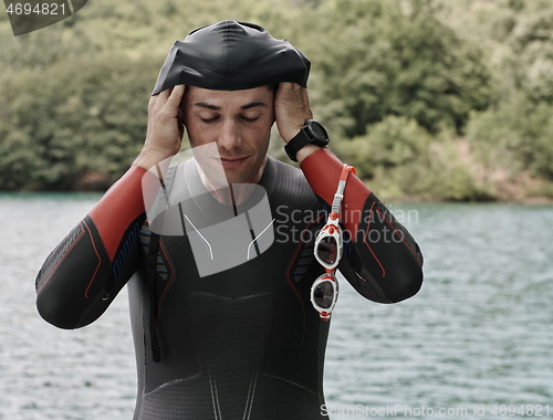 Image of triathlon athlete getting ready for swimming training on lake