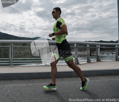 Image of triathlon athlete running on street