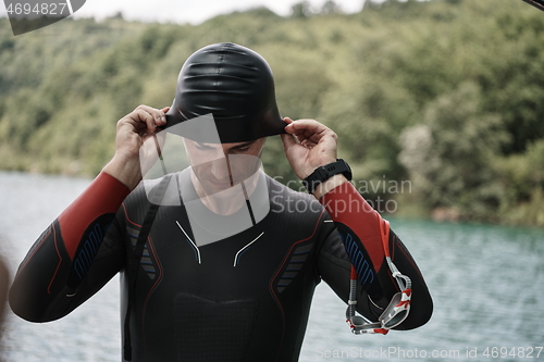 Image of triathlon athlete getting ready for swimming training on lake