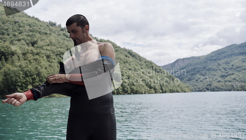 Image of triathlon athlete getting ready for swimming training on lake