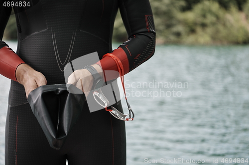 Image of triathlon athlete getting ready for swimming training on lake