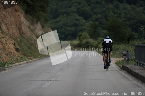 Image of triathlon athlete riding a bike wearing black