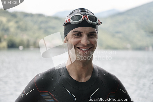 Image of triathlete swimmer portrait wearing wetsuit on training