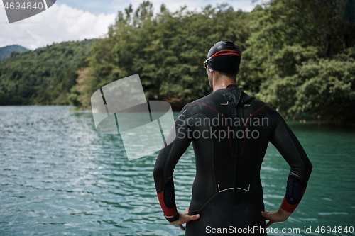 Image of triathlete swimmer portrait wearing wetsuit on training