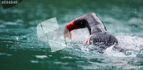 Image of triathlon athlete swimming on lake wearing wetsuit