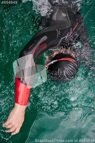 Image of triathlon athlete swimming on lake wearing wetsuit