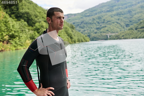 Image of triathlete swimmer portrait wearing wetsuit on training