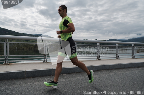 Image of triathlon athlete running on street