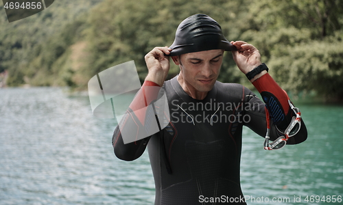 Image of triathlon athlete getting ready for swimming training on lake