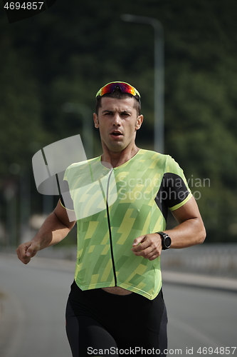 Image of triathlon athlete running on street