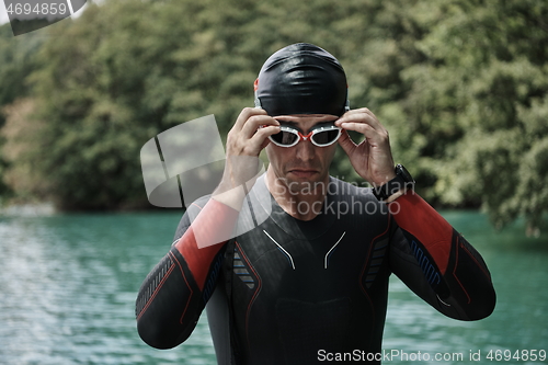 Image of triathlon athlete getting ready for swimming training on lake