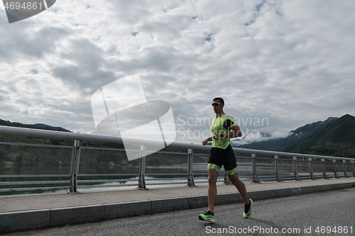 Image of triathlon athlete running on street