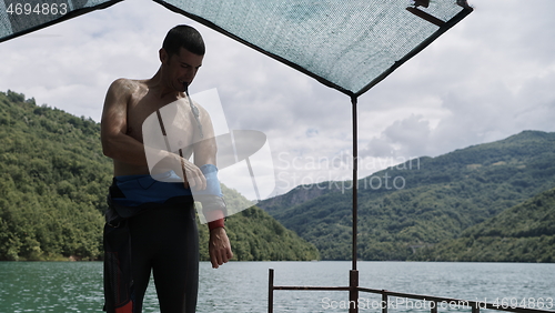 Image of triathlon athlete getting ready for swimming training on lake