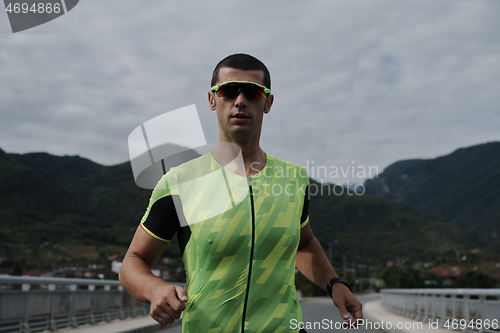 Image of triathlon athlete running on street