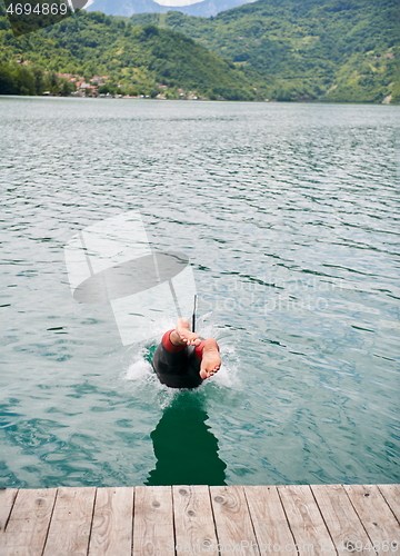 Image of triathlon athlete jumping in water and starting with training