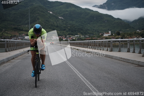 Image of triathlon athlete riding a bike on morning training