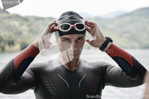 Image of triathlon athlete getting ready for swimming training on lake