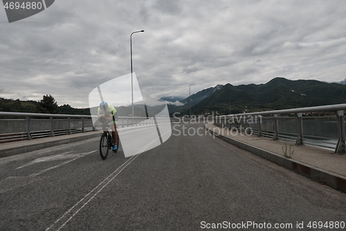 Image of triathlon athlete riding a bike on morning training