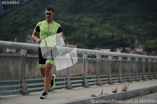 Image of triathlon athlete running on street