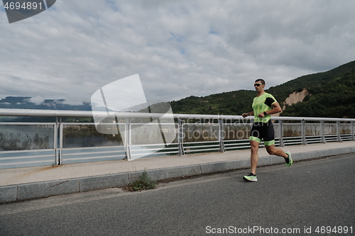 Image of triathlon athlete running on street