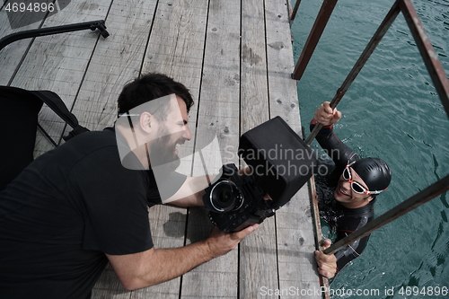 Image of videographer taking action shot of triathlon swimming athlete