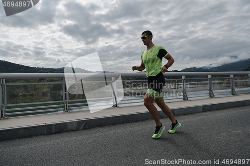 Image of triathlon athlete running on street