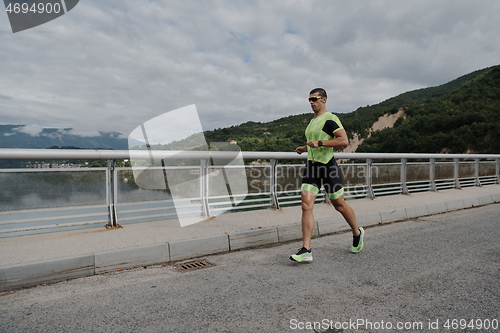 Image of triathlon athlete running on street