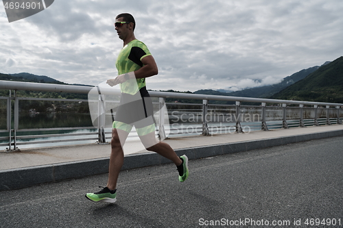 Image of triathlon athlete running on street