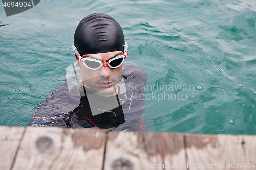 Image of triathlete swimmer portrait wearing wetsuit on training