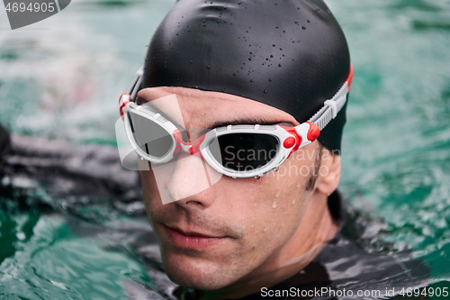 Image of triathlete swimmer portrait wearing wetsuit on training