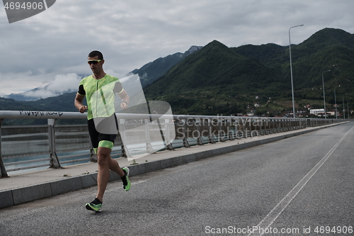 Image of triathlon athlete running on street