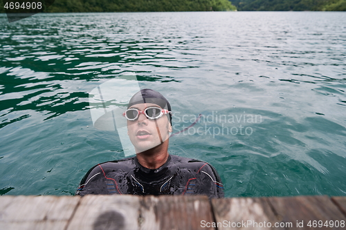 Image of triathlete swimmer portrait wearing wetsuit on training