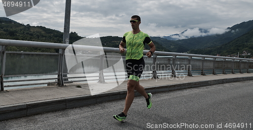 Image of triathlon athlete running on street