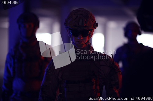 Image of soldier squad team portrait in urban environment colored lightis