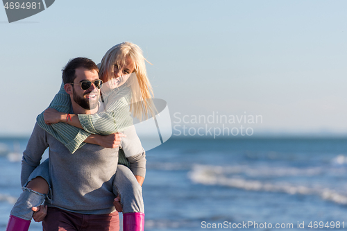 Image of couple having fun at beach during autumn