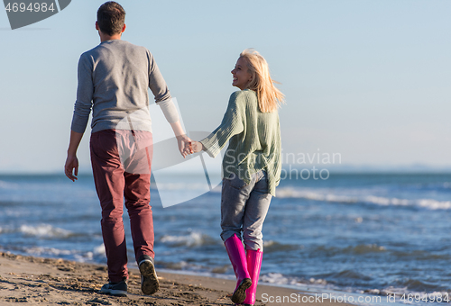 Image of Loving young couple on a beach at autumn sunny day