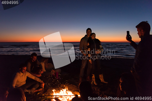 Image of Friends having fun at beach on autumn day